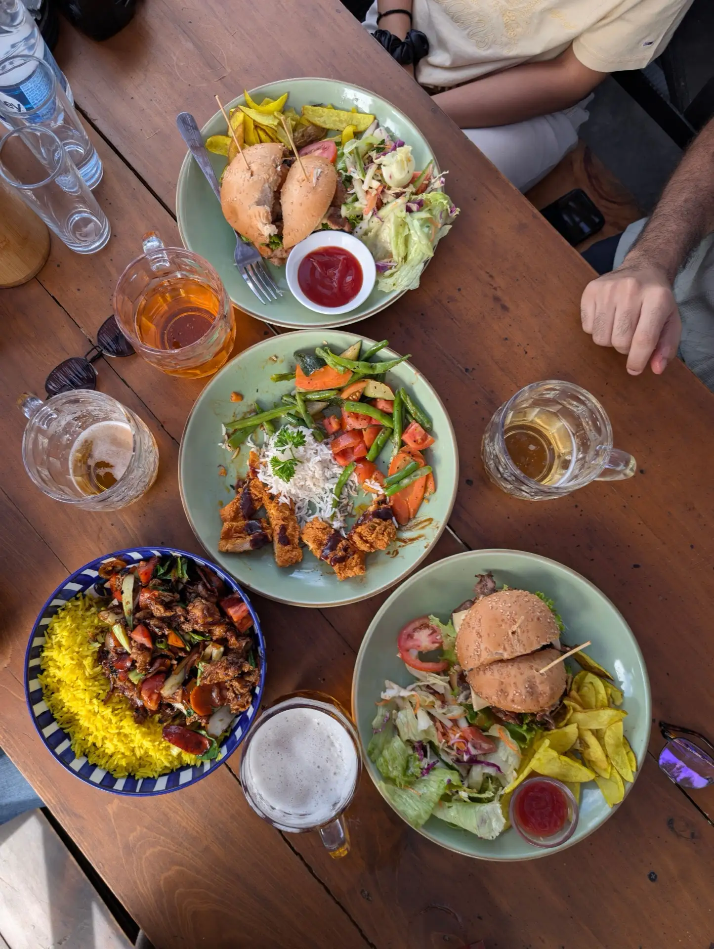 A spread of Sri Lankan dishes and drinks laid out on an outdoor table.