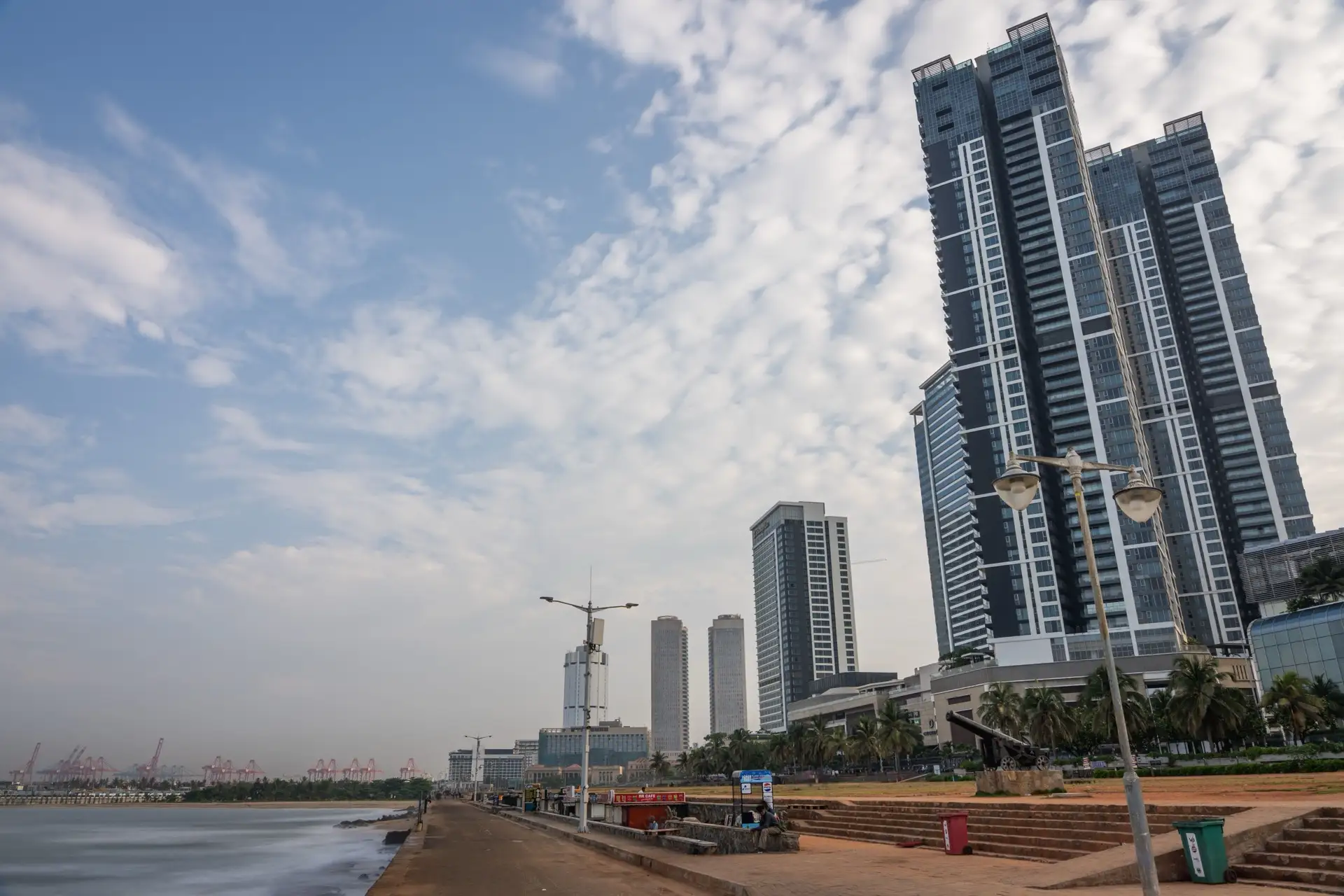 The Galle Face Green seafront promenade in Colombo with high-rise towers behind it and the port cranes in the distance.